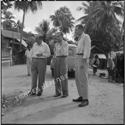 Le directeur du service de l'information américain, Jean Barré et l'adjoint du commissaire de Battambang, lors d'une halte dans un village.