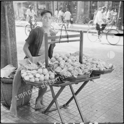 Un marchand de fruits dans une rue.