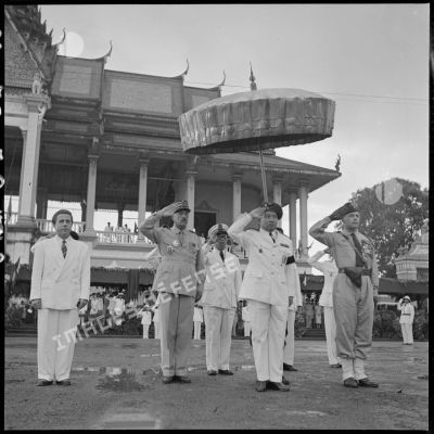 Les autorités au salut pendant les hymnes nationaux au cours de la cérémonie de transfert du commandement militaire au gouvernement royal cambodgien.