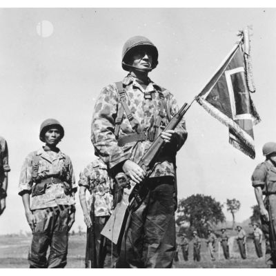 Lors d'une prise d'armes à Na San, le chef de bataillon Bonnigal, commandant le 3e bataillon de parachutistes coloniaux (BPC) et le fanion de son unité.