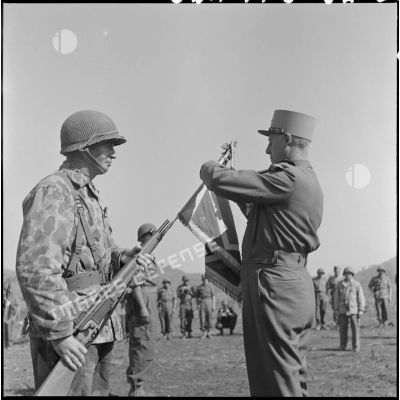 Le général Salan, commandant en chef en Indochine, remet la croix de guerre avec palme au fanion du 3e bataillon de parachutistes coloniaux (3e BPC), qui s'est illustré pendant la bataille de Na San.