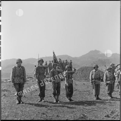 Le chef de bataillon Bonnigal, commandant le 3e bataillon de parachutistes coloniaux (3e BPC) et la garde d'honneur du fanion de son unité au cours d'une remise de décorations à Na San.