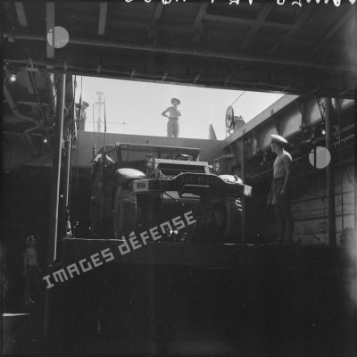 Embarquement d'un scout car sur le LST Rance sous la surveillance de l'ingénieur mécanicien.