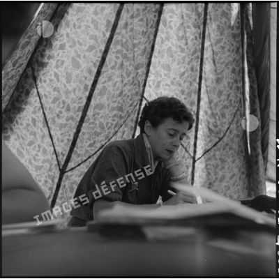 A Muong Khoua sous une tente en parachute, la journaliste Brigitte Friang du Service français d'information (SFI) rédige son article.