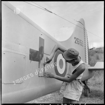 Peinture du signe de la Croix-Rouge sur un avion sanitaire Beaver servant au rapatriement des blessés de Diên Biên Phu.