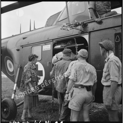 Arrivée des premiers grands blessés de Diên Biên Phu par hélicoptère Sikorsky sur le terrain d'aviation de Luang Prabang, immédiatement pris en charge par le personnel médical.