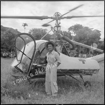 Le médecin-capitaine Valérie André pose devant son hélicoptère Hiller 360 au cours d'une évacuation sanitaire au Tonkin.