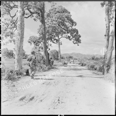 Des parachutistes progressent à couvert sur la route vers Lang Son au cours de l'opération Hirondelle..