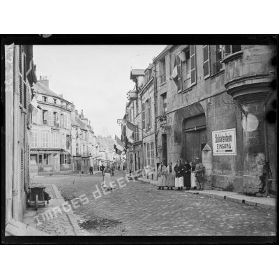 Laon (Aisne). Groupe d'habitants dans la rue Saint-Martin pavoisée, au premier plan écriteau allemand "entrée du Foyer du soldat". [légende d'origine]