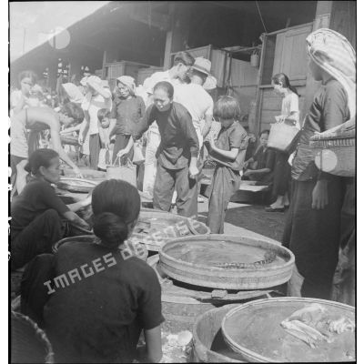 Des vendeurs de poisson frais sur un marché de Saigon.