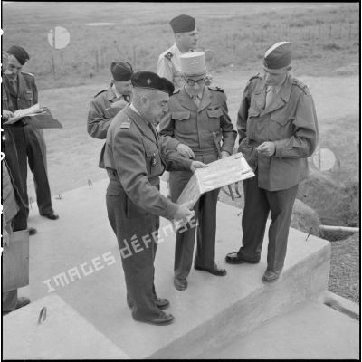 Au cours d'une inspection du général Navarre au poste de Thuy Phieu, examen de la carte avec le colonel Quilichini, commandant le secteur (à gauche) et le colonel De Clerk (à droite) commandant la 1e division militaire territoriale (DMT).