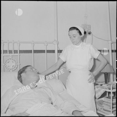 Le cameraman André Lebon, blessé à Diên Biên Phu, en compagnie d'une infirmière pendant sa sonvalescence à l'hôpital Grall de Saigon.