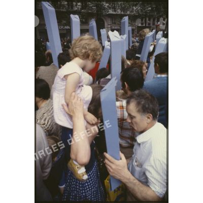 Lors du défilé du 14 juillet 1979 à la Bastille, le public est équipé de périscopes en papier, ou juche les plus jeunes sur les épaules.