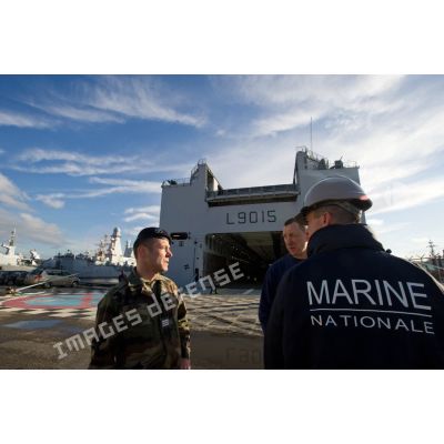 Des marins du service pont font un point de situation pour l'embarquement de véhicules à bord du bâtiment de projection et de commandement Dixmude (L9015) à Toulon.