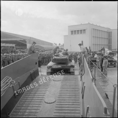 Un char AMX 13 débarque d’une barge. [Description en cours]