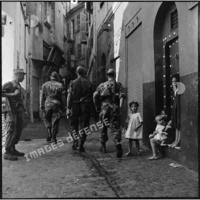 Des éléments du 3e régiment de parachutistes coloniaux (3e RPC) patrouillent dans la casbah d'Alger sous les yeux d'enfants.