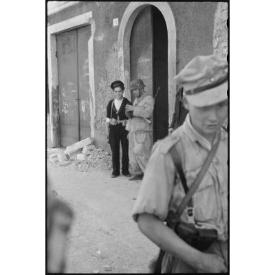 Un marin italien et des fantassins du Panzer-Grenadier-Regiment Hermann Goering dans une rue de Catane (Sicile).