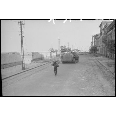 En Sicile, dans la ville de Catane ou à proximité, un canon d'assaut Sturmgeschütz III de la III./Panzer-Regiment  Hermann Goering rejoint le front après avoir été approvisionné en obus.