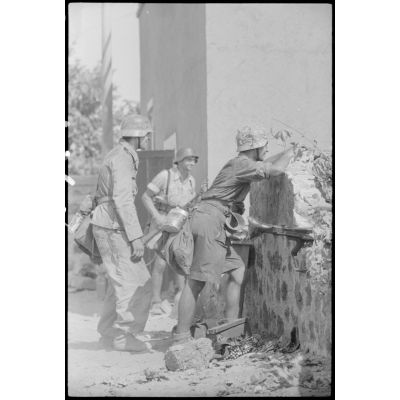 A Catane (Sicile) ou dans la banlieue de la ville, des fantassins du Panzergrenadier-Regiment Hermann Goering protégés derrière un mur.