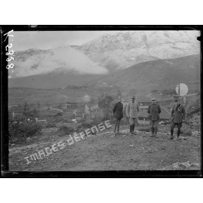 [A Bratomir, photographie de groupe rassemblant des autorités militaires devant un village, en pleine montagne.]