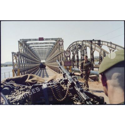 Le véhicule transportant le photographe passe le pont du lac Delcommune tenu par les hommes du 2e régiment étranger parachutiste (2e REP).  [Description en cours]