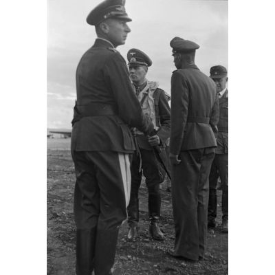 Sur le terrain d'aviation d'Héraklion (Crète), revêtu d'un gilet de sauvetage, le maréchal Erwin Rommel s'apprête à quitter le général (Generalleutnant) von Waldau et le général (Generalmajor) Müller.