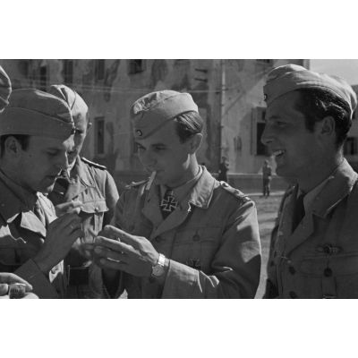 A l'issue de la cérémonie, le lieutenant Iro Ilk fume une cigarette en compagnie des camarades du groupe aérien (1./Lehrgeschwader I).