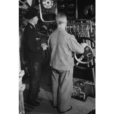 Un Sonderführer et un mécanicien dans la salle des machines d'un dragueur de mines (Minensuchboot) de la Kriegsmarine.