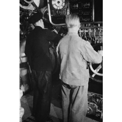 Un Sonderführer et un mécanicien dans la salle des machines d'un dragueur de mines (Minensuchboot) de la Kriegsmarine.