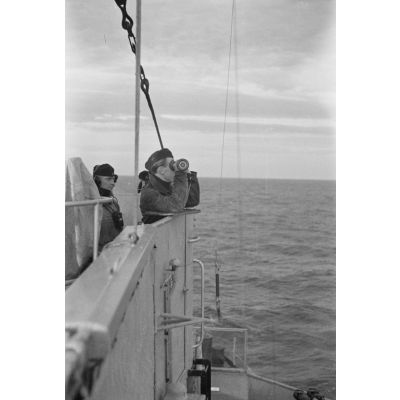 A bord d'un dragueur de mines allemand (Minensuchboot), des marins observent l'horizon à la recherche de mines anglaises à l'aide d'un télémètre portatif (Entfernungsmesser).