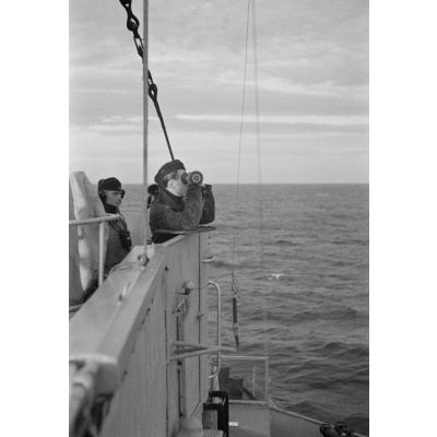A bord d'un dragueur de mines allemand (Minensuchboot), des marins observent l'horizon à la recherche de mines anglaises à l'aide d'un télémètre portatif (Entfernungsmesser).