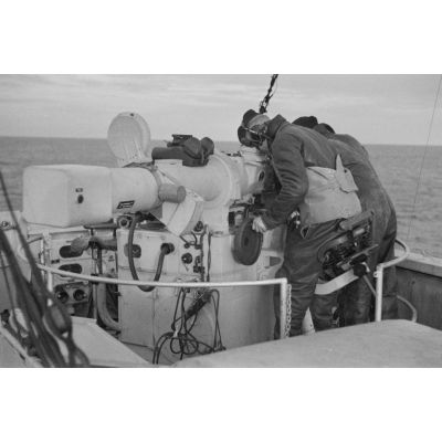 A bord d'un dragueur de mines allemand (Minensuchboot), des marins observent l'horizon à la recherche de mines anglaises à l'aide d'un télémètre lourd (Entfernungsmesser et Kommandogerat 40).