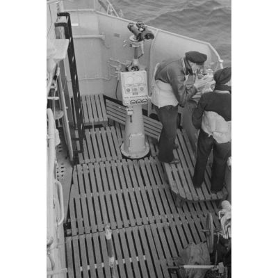 A bord d'un dragueur de mines allemand (Minensuchboot), des marins observent l'horizon à la recherche de mines anglaises à l'aide de jumelles.