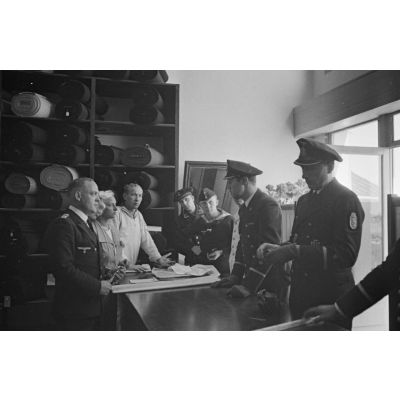 Des membres de la 2e compagnie de propagande de la marine allemande (Marine Kriegsberichter Kompanie 2) rendent visite à un maitre-tailleur de la Kriegsmarine.