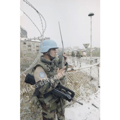 Compte-rendu radio lors d'une patrouille à pied sur le pont de Vrbanja à Sarejevo de casques bleus du bataillon d'infanterie (BATINF) 4, armé par les militaires du 3e régiment parachutiste d'infanterie de marine (3e RPIMa).