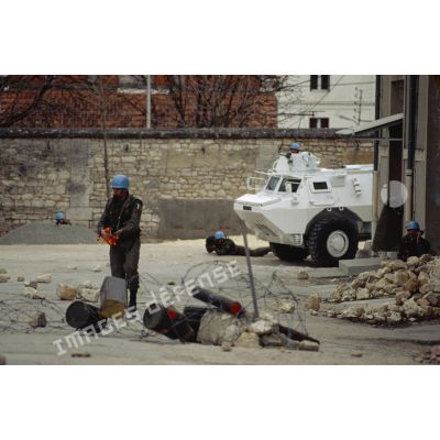 Casques bleus du 1er régiment d'infanterie de marine (1er RIMa) à pieds appuyés par un véhicule blindé de l'avant, s'exerçant à progresser en zone de combat urbain avant le départ pour la Bosnie.