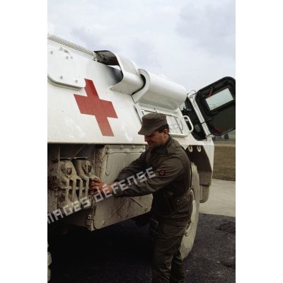 Un personnel du Service de Santé du 2e régiment d'infanterie de marine (2e RIMa) vérifie la fixation des bidons d'essence sur un véhicule sanitaire avant le départ pour la FORPRONU.