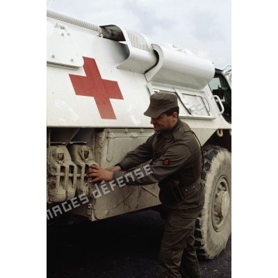 Un personnel du Service de Santé du 2e régiment d'infanterie de marine (2e RIMa) vérifie la fixation des bidons d'essence sur un véhicule de l'avant blindé (VAB) sanitaire.