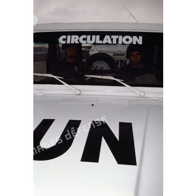 Gros plan sur l'avant d'une Peugeot P4 aux couleurs de l'ONU arborant l'inscription CIRCULATION sur son pare-brise.