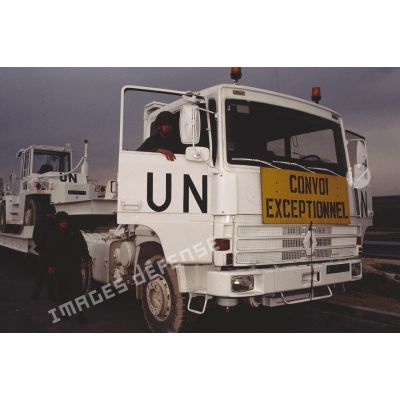 Gros plan sur l'avant d'un camion Renault TBH 350 aux couleurs de l'ONU transportant un engin du génie.