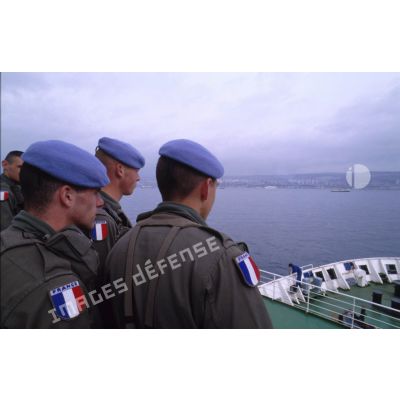 Trois marsouins du 2e régiment d'infanterie de marine (2e RIMa) de profil regardant au loin le port de Rijeka sur le pont du ferry Esterel.