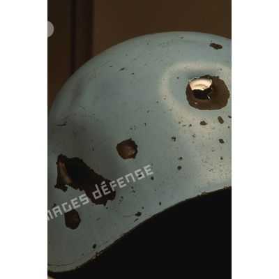 Impacts sur un casque bleu appartenant à un sergent du 8e régiment d'infanterie (8e RI) ayant été blessé à la tête par balle en ex-Yougoslavie.