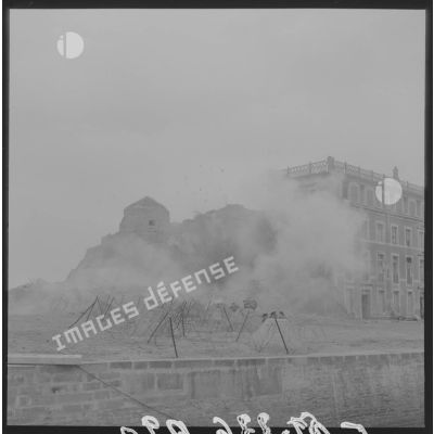 Sur le tournage du film Le jour le plus long en Normandie. Les figurants se déploient lors d'une scène de combat sur le port en centre-ville. En arrière-plan, la tour Vauban.