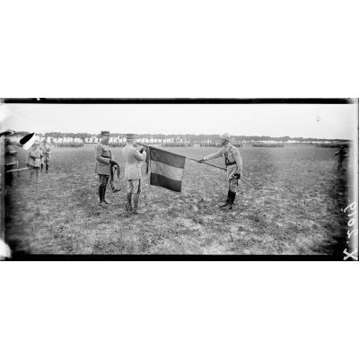 Près de Bergues (Nord), le général Pétain remet la fouragère à un drapeau. [légende d'origine]