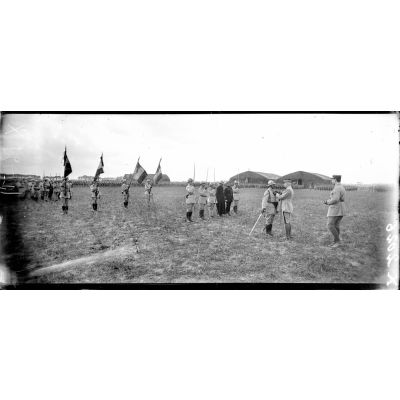 Près de Bergues (Nord), le général Pétain remet la Croix de guerre au drapeau du 33e et 235e. [légende d'origine]
