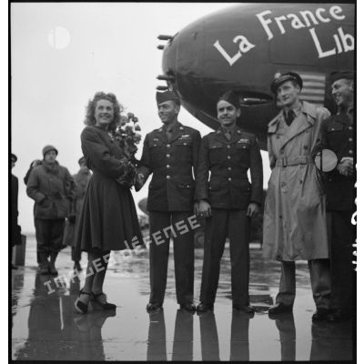 Monique Rolland sert la main d'un caporal chef américain lors de la cérémonie officielle du baptême de l'avion "France Libre" le 25 octobre 1944, au Bourget.