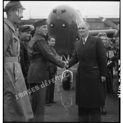 Tillon sert la main à un caporal chef américain lors de la cérémonie officielle du baptême de l'avion "France Libre" le 25 octobre 1944, au Bourget.