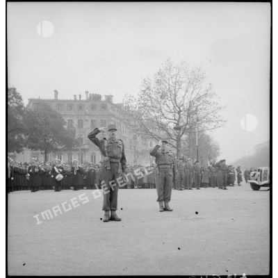 Le général Koenig arrive sur les Champs-Elysées pour la cérémonie du 11 novembre à Paris, en 1944, puis fait le salut militaire.