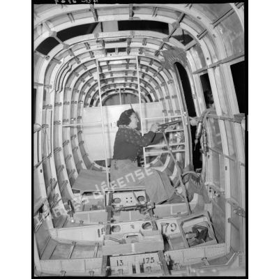 Revêtement des tôles d'un fuselage d'un avion NC 701 Siebel Martinet dans une usine S.N.C.A.C. (Société Nationale des Constructions Aéronautiques du Centre).