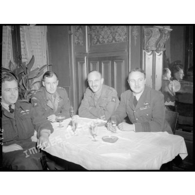 Le capitaine Hockie, le colonel Prendergast, le brigadier général Mac Leod et le Wing commander Joël, assis autour d'une table.